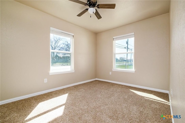 empty room featuring baseboards, carpet floors, and ceiling fan