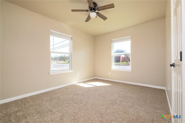 carpeted spare room featuring baseboards and ceiling fan