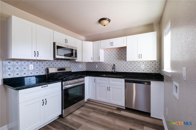 kitchen with a sink, appliances with stainless steel finishes, and white cabinets