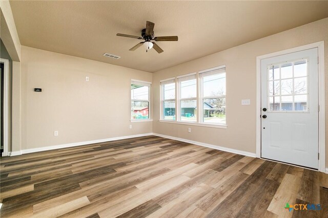 entryway with baseboards, wood finished floors, visible vents, and ceiling fan