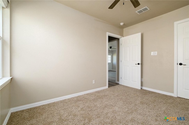unfurnished bedroom featuring visible vents, carpet floors, baseboards, and a ceiling fan