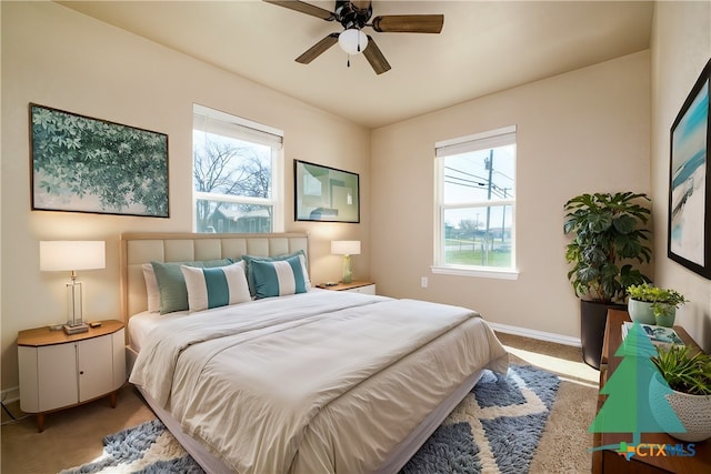 bedroom featuring ceiling fan, baseboards, and carpet