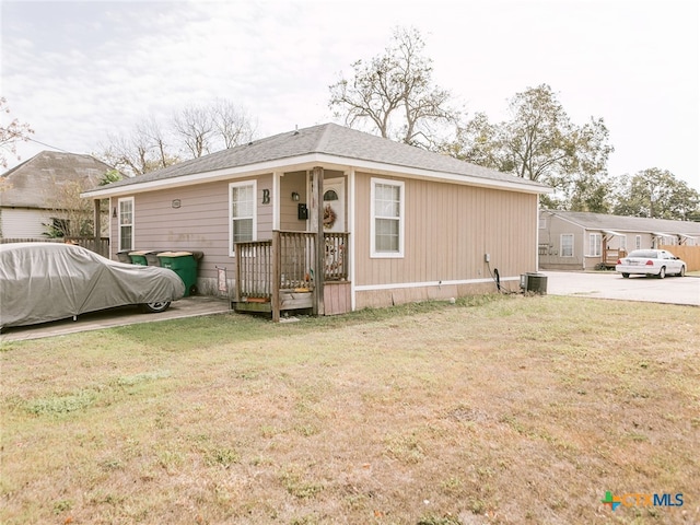 exterior space with central air condition unit and a lawn