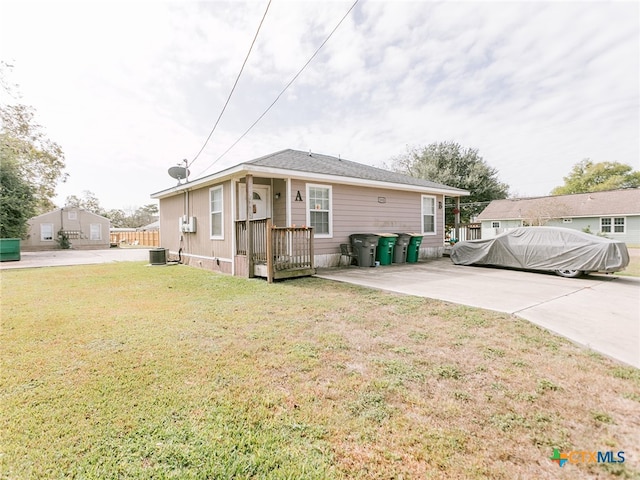 view of front of home with central AC unit and a front yard