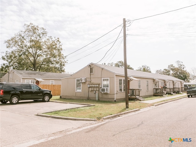 view of front of house with a front yard and cooling unit