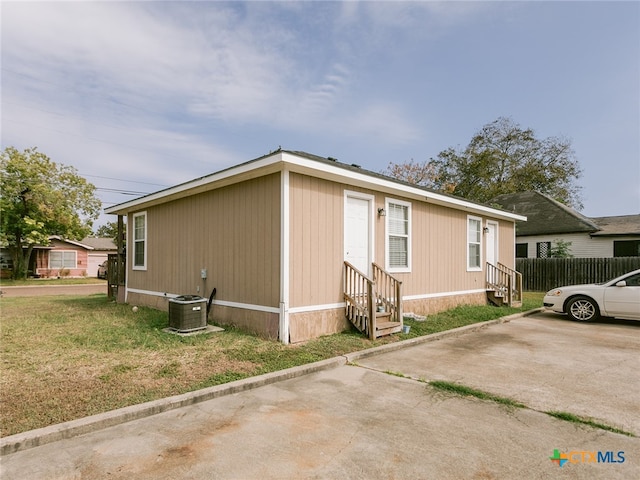 view of home's exterior featuring central AC and a yard