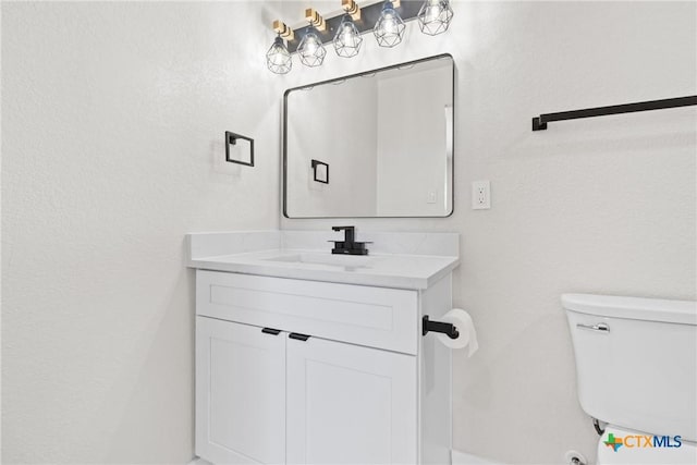 bathroom featuring toilet and vanity