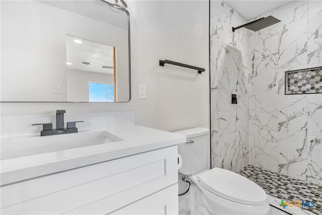 full bath featuring a stall shower, vanity, and toilet