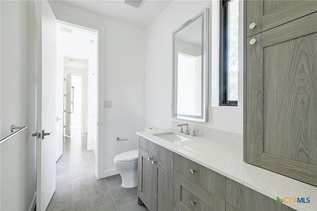 bathroom featuring toilet, vanity, and tile patterned floors