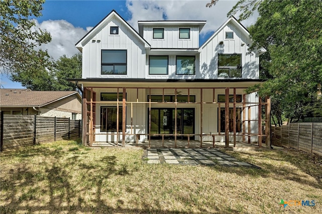 back of property featuring a lawn and a patio area