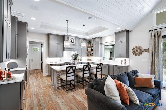 kitchen with pendant lighting, gray cabinets, and light wood-type flooring