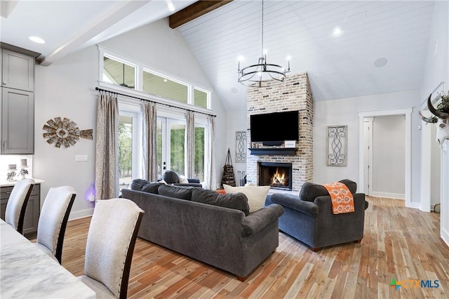 living room with a fireplace, beam ceiling, light hardwood / wood-style flooring, and high vaulted ceiling