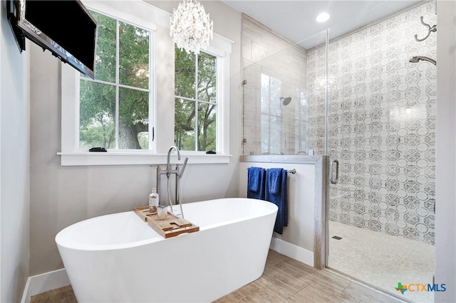 bathroom featuring hardwood / wood-style flooring and plus walk in shower