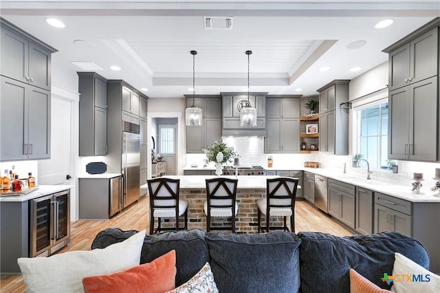 kitchen featuring pendant lighting, gray cabinets, and a raised ceiling