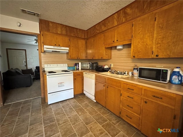 kitchen with visible vents, white appliances, light countertops, under cabinet range hood, and a sink
