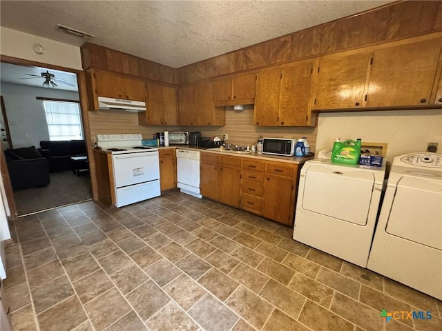 kitchen with washing machine and clothes dryer, white appliances, a ceiling fan, under cabinet range hood, and visible vents
