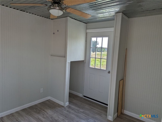 doorway with ceiling fan and wood-type flooring