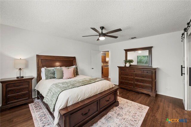 2711 Oak Leigh St, San Antonio, TX 78232 - bedroom with a textured ceiling, dark wood-style flooring, a ceiling fan, and a barn door