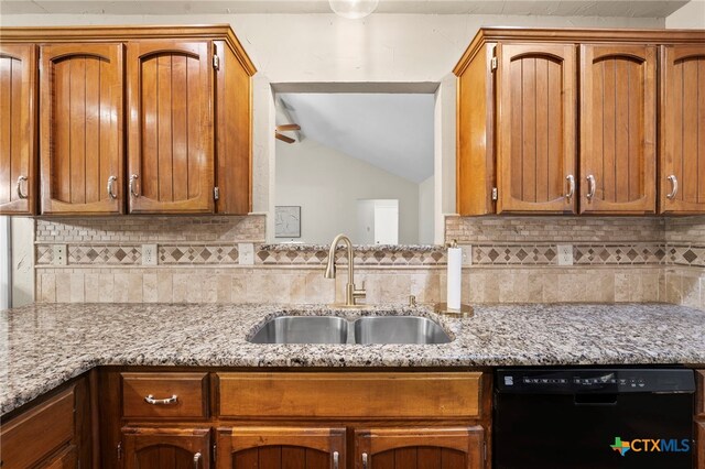 2711 Oak Leigh St, San Antonio, TX 78232 - kitchen with black dishwasher, decorative backsplash, light stone counters, vaulted ceiling, and brown cabinets