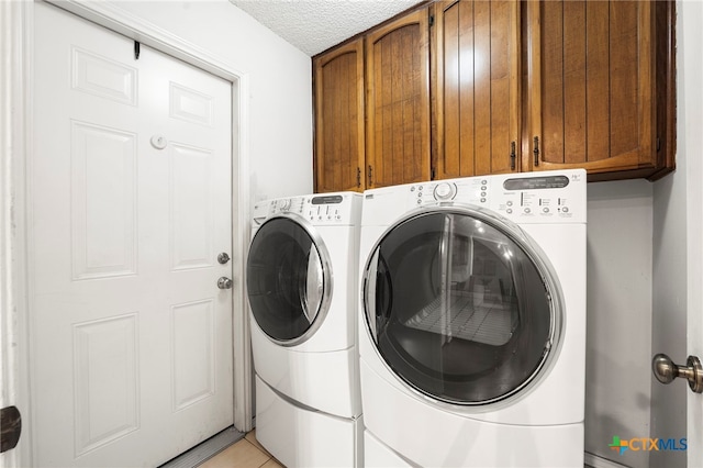 2711 Oak Leigh St, San Antonio, TX 78232 - washroom with cabinet space, washing machine and clothes dryer, a textured ceiling, and light tile patterned flooring