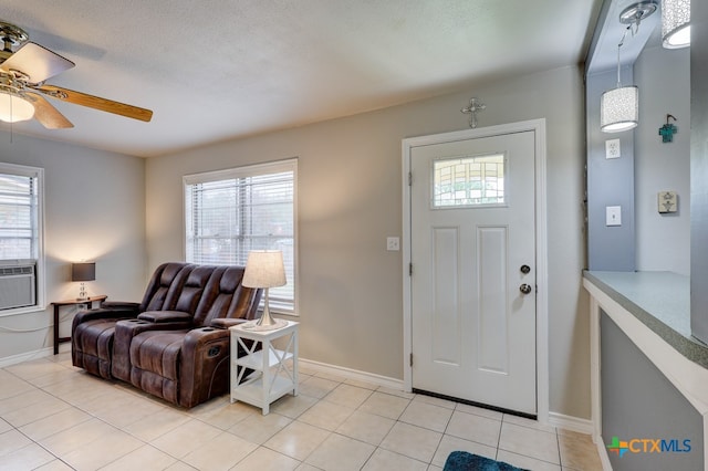 tiled foyer featuring a textured ceiling, ceiling fan, and a healthy amount of sunlight