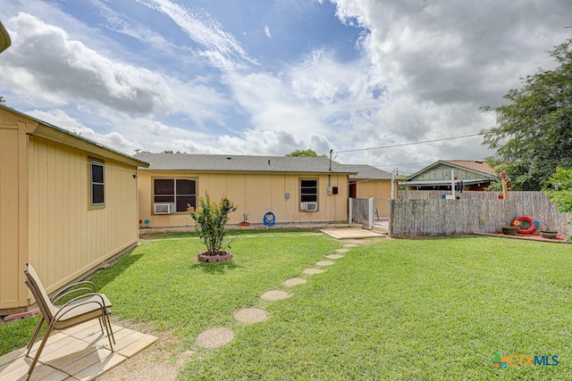 back of house featuring a lawn and cooling unit