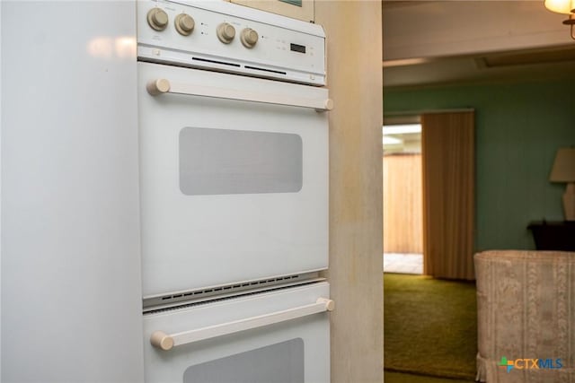kitchen with double oven and carpet flooring