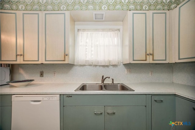 kitchen with green cabinetry, white dishwasher, light countertops, and a sink