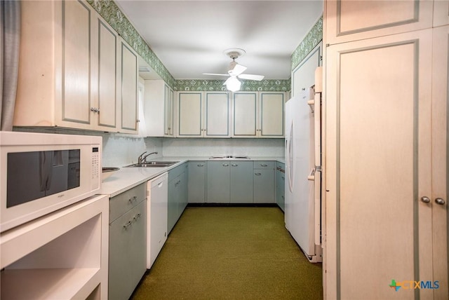 kitchen with light countertops, white appliances, decorative backsplash, a sink, and ceiling fan