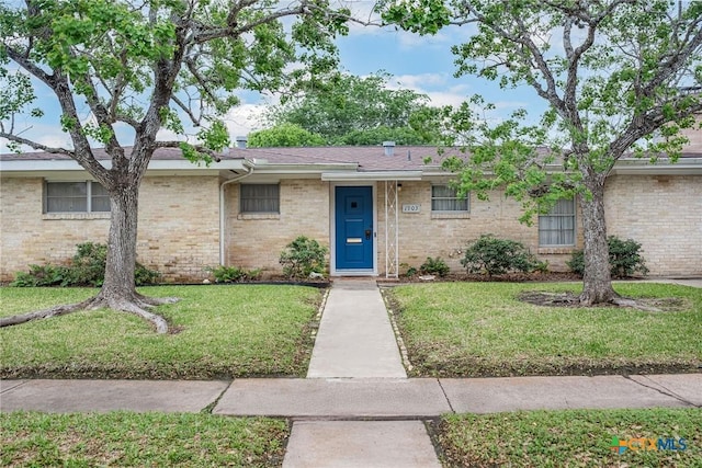 ranch-style home with brick siding and a front yard