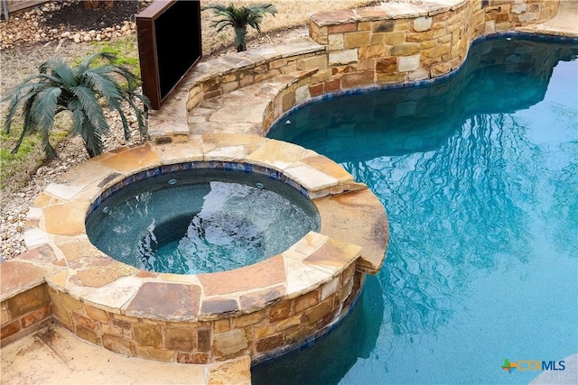 view of pool with an in ground hot tub