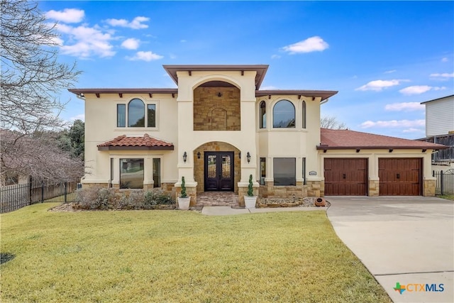 mediterranean / spanish-style house featuring french doors, a front lawn, and a garage