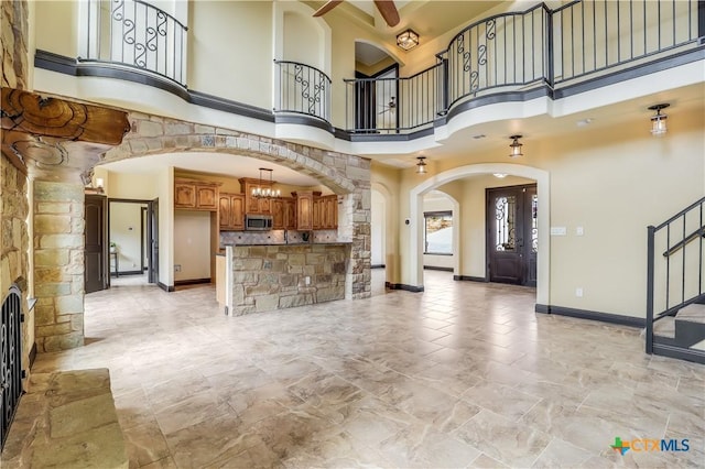 interior space with a high ceiling and ceiling fan