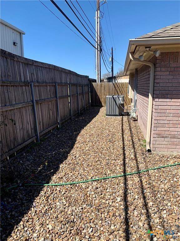 view of yard featuring a fenced backyard and central AC