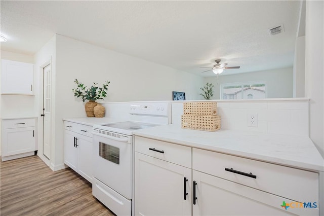 706 Joe Morse Dr, Copperas Cove, TX 76522 - kitchen with white electric range oven, a ceiling fan, white cabinets, light countertops, and light wood-style flooring