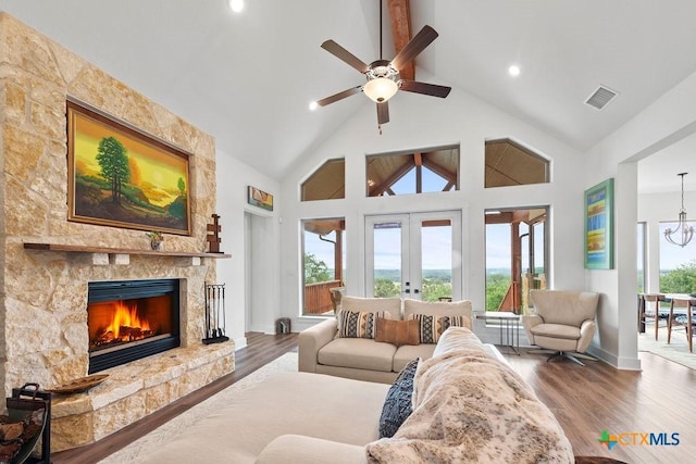 213 Lets Roll Dr, Fischer, TX 78623 - living area featuring high vaulted ceiling, plenty of natural light, a ceiling fan, a stone fireplace, and wood finished floors