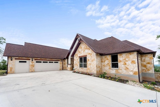 213 Lets Roll Dr, Fischer, TX 78623 - view of front facade with stone siding, a garage, driveway, and roof with shingles