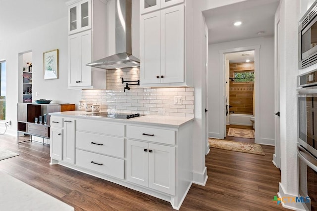 213 Lets Roll Dr, Fischer, TX 78623 - kitchen with wall chimney exhaust hood, stainless steel microwave, black electric cooktop, dark wood finished floors, and backsplash
