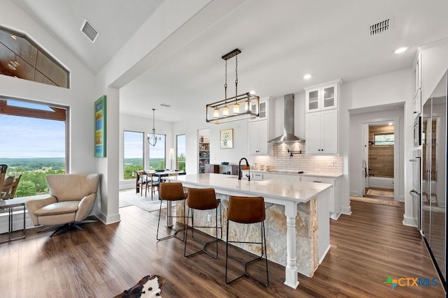 213 Lets Roll Dr, Fischer, TX 78623 - kitchen featuring wall chimney range hood, light countertops, a kitchen island with sink, decorative backsplash, and appliances with stainless steel finishes