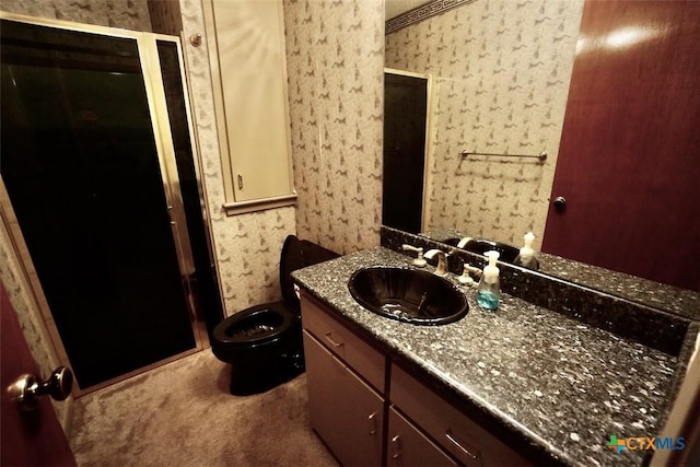 bathroom featuring wallpapered walls, vanity, and a stall shower