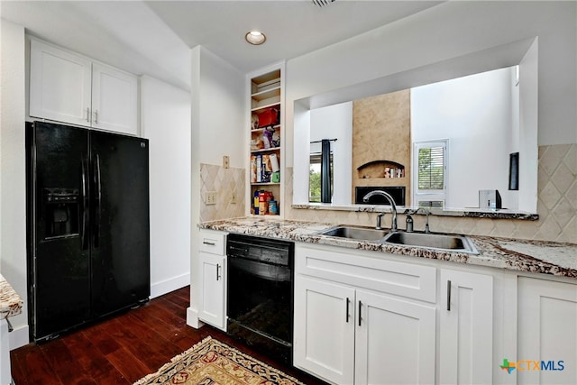 kitchen featuring black appliances, light stone countertops, sink, and white cabinets