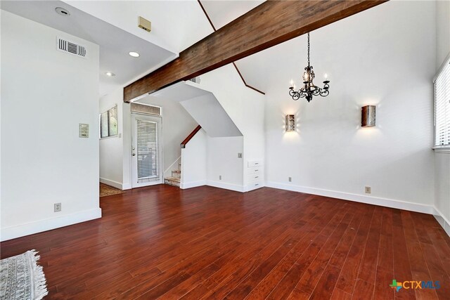 unfurnished living room featuring a wealth of natural light, dark wood-type flooring, and beam ceiling