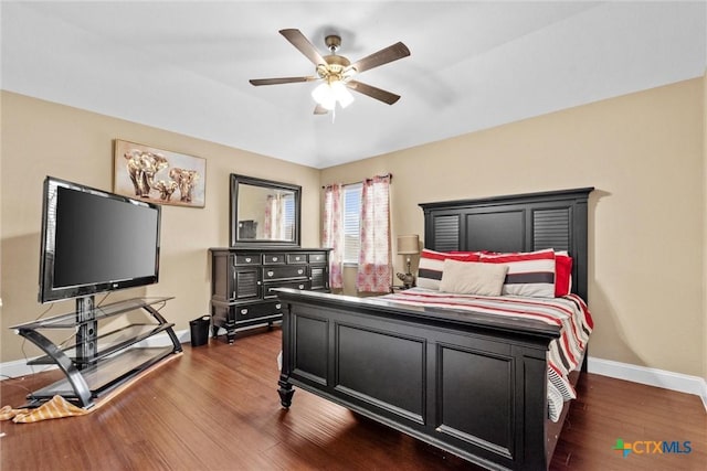 bedroom featuring baseboards, dark wood finished floors, and a ceiling fan