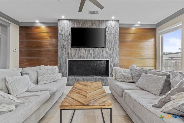 living area with a large fireplace, visible vents, a ceiling fan, crown molding, and recessed lighting