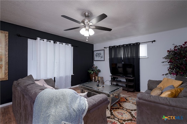 living room with hardwood / wood-style floors, ceiling fan, and a textured ceiling