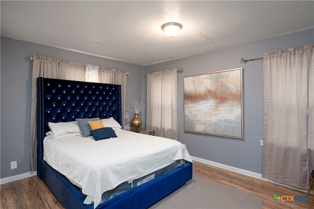 bedroom featuring wood-type flooring and a textured ceiling