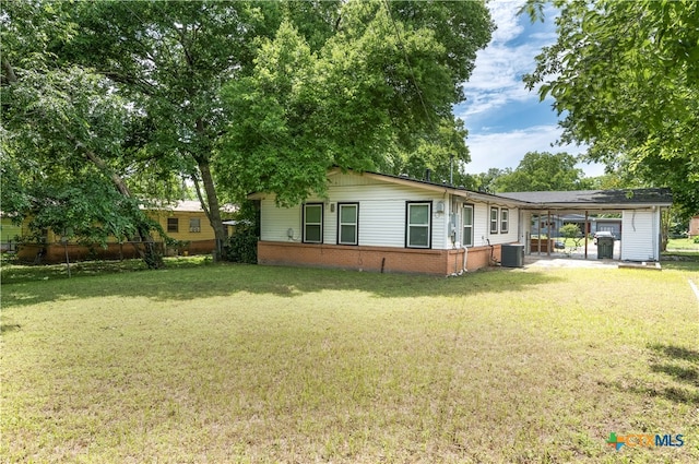 exterior space with central AC unit and a yard