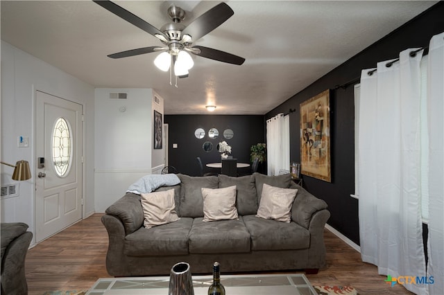 living room with dark hardwood / wood-style flooring and ceiling fan