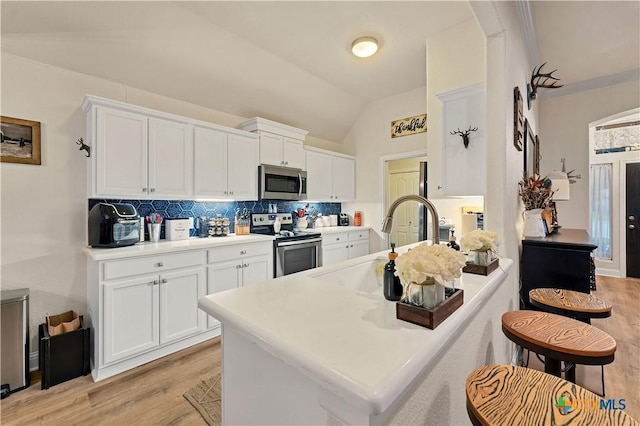 kitchen with tasteful backsplash, stainless steel appliances, and white cabinets