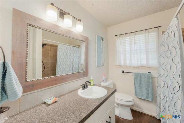 bathroom with hardwood / wood-style floors, vanity, a textured ceiling, and toilet